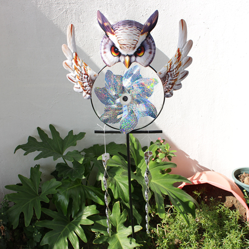 Owl-shaped iron wind chime with a rotating central ornament and two stakes