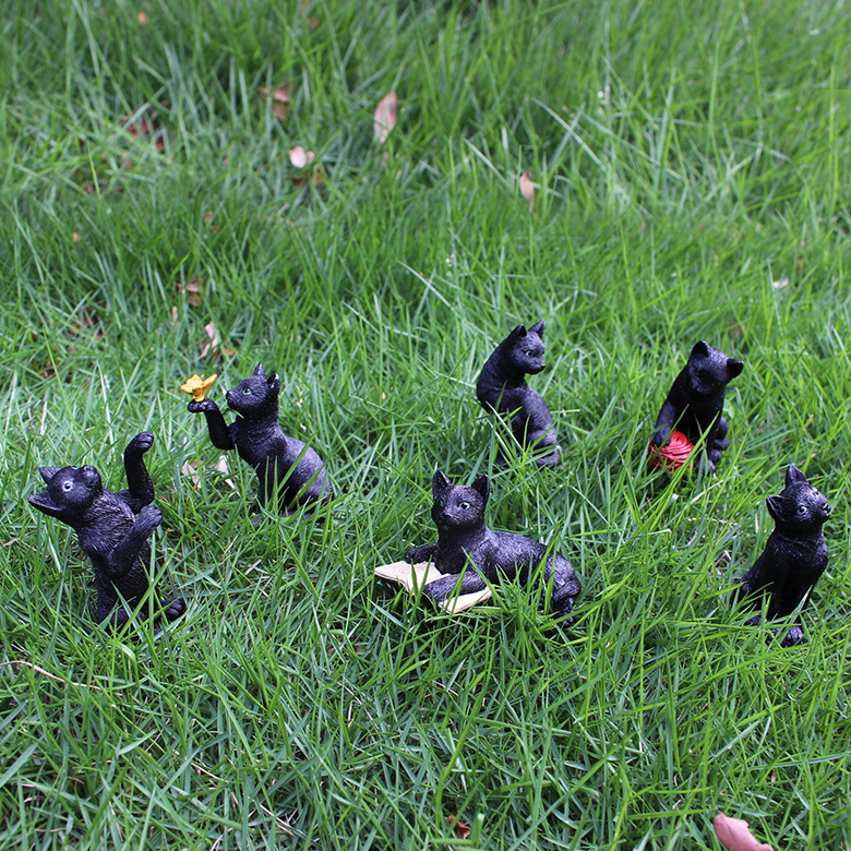 Miniature black cat resin ornaments photographed on grass
